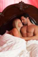 Sexy sensual heterosexual couple, man, young caucasian woman in love on bed kissing, hugging. Beautiful passionate couple is having sex in a bedroom. Portrait of passion, pleasure, sex, relationship. Copulating