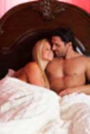 Sexy sensual heterosexual couple, man, young caucasian woman in love on bed kissing, hugging. Beautiful passionate couple is having sex in a bedroom. Portrait of passion, pleasure, sex, relationship. Copulating