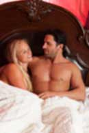 Sexy sensual heterosexual couple, man, young caucasian woman in love on bed kissing, hugging. Beautiful passionate couple is having sex in a bedroom. Portrait of passion, pleasure, sex, relationship. Copulating