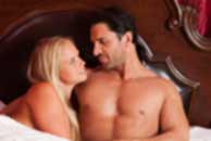 Sexy sensual heterosexual couple, man, young caucasian woman in love on bed kissing, hugging. Beautiful passionate couple is having sex in a bedroom. Portrait of passion, pleasure, sex, relationship. Copulating