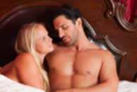 Sexy sensual heterosexual couple, man, young caucasian woman in love on bed kissing, hugging. Beautiful passionate couple is having sex in a bedroom. Portrait of passion, pleasure, sex, relationship. Copulating