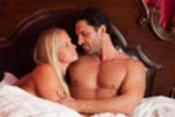 Sexy sensual heterosexual couple, man, young caucasian woman in love on bed kissing, hugging. Beautiful passionate couple is having sex in a bedroom. Portrait of passion, pleasure, sex, relationship. Copulating