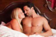 Sexy sensual heterosexual couple, man, young caucasian woman in love on bed kissing, hugging. Beautiful passionate couple is having sex in a bedroom. Portrait of passion, pleasure, sex, relationship. Copulating