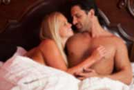 Sexy sensual heterosexual couple, man, young caucasian woman in love on bed kissing, hugging. Beautiful passionate couple is having sex in a bedroom. Portrait of passion, pleasure, sex, relationship. Copulating