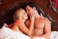 Sexy sensual heterosexual couple, man, young caucasian woman in love on bed kissing, hugging. Beautiful passionate couple is having sex in a bedroom. Portrait of passion, pleasure, sex, relationship. Copulating