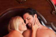 Sexy sensual heterosexual couple, man, young caucasian woman in love on bed kissing, hugging. Beautiful passionate couple is having sex in a bedroom. Portrait of passion, pleasure, sex, relationship. Copulating