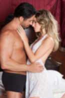 Sexy sensual heterosexual couple, man, young caucasian woman in love on bed kissing, hugging. Beautiful passionate couple is having sex in a bedroom. Portrait of passion, pleasure, sex, relationship. Copulating