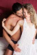 Sexy sensual heterosexual couple, man, young caucasian woman in love on bed kissing, hugging. Beautiful passionate couple is having sex in a bedroom. Portrait of passion, pleasure, sex, relationship. Copulating