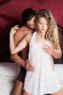 Sexy sensual heterosexual couple, man, young caucasian woman in love on bed kissing, hugging. Beautiful passionate couple is having sex in a bedroom. Portrait of passion, pleasure, sex, relationship. Copulating