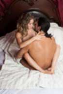 Sexy sensual heterosexual couple, man, young caucasian woman in love on bed kissing, hugging. Beautiful passionate couple is having sex in a bedroom. Portrait of passion, pleasure, sex, relationship. Copulating