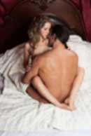 Sexy sensual heterosexual couple, man, young caucasian woman in love on bed kissing, hugging. Beautiful passionate couple is having sex in a bedroom. Portrait of passion, pleasure, sex, relationship. Copulating
