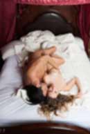 Sexy sensual heterosexual couple, man, young caucasian woman in love on bed kissing, hugging. Beautiful passionate couple is having sex in a bedroom. Portrait of passion, pleasure, sex, relationship. Copulating