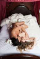 Sexy sensual heterosexual couple, man, young caucasian woman in love on bed kissing, hugging. Beautiful passionate couple is having sex in a bedroom. Portrait of passion, pleasure, sex, relationship. Copulating