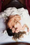 Sexy sensual heterosexual couple, man, young caucasian woman in love on bed kissing, hugging. Beautiful passionate couple is having sex in a bedroom. Portrait of passion, pleasure, sex, relationship. Copulating