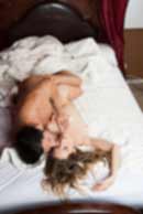 Sexy sensual heterosexual couple, man, young caucasian woman in love on bed kissing, hugging. Beautiful passionate couple is having sex in a bedroom. Portrait of passion, pleasure, sex, relationship. Copulating