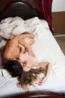 Sexy sensual heterosexual couple, man, young caucasian woman in love on bed kissing, hugging. Beautiful passionate couple is having sex in a bedroom. Portrait of passion, pleasure, sex, relationship. Copulating