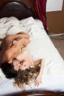 Sexy sensual heterosexual couple, man, young caucasian woman in love on bed kissing, hugging. Beautiful passionate couple is having sex in a bedroom. Portrait of passion, pleasure, sex, relationship. Copulating