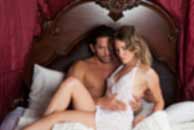 Sexy sensual heterosexual couple, man, young caucasian woman in love on bed kissing, hugging. Beautiful passionate couple is having sex in a bedroom. Portrait of passion, pleasure, sex, relationship. Copulating