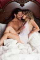 Sexy sensual heterosexual couple, man, young caucasian woman in love on bed kissing, hugging. Beautiful passionate couple is having sex in a bedroom. Portrait of passion, pleasure, sex, relationship. Copulating
