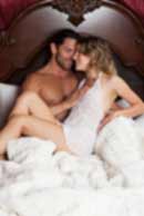 Sexy sensual heterosexual couple, man, young caucasian woman in love on bed kissing, hugging. Beautiful passionate couple is having sex in a bedroom. Portrait of passion, pleasure, sex, relationship. Copulating