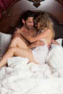 Sexy sensual heterosexual couple, man, young caucasian woman in love on bed kissing, hugging. Beautiful passionate couple is having sex in a bedroom. Portrait of passion, pleasure, sex, relationship. Copulating