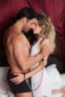 Sexy sensual heterosexual couple, man, young caucasian woman in love on bed kissing, hugging. Beautiful passionate couple is having sex in a bedroom. Portrait of passion, pleasure, sex, relationship. Copulating