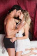 Sexy sensual heterosexual couple, man, young caucasian woman in love on bed kissing, hugging. Beautiful passionate couple is having sex in a bedroom. Portrait of passion, pleasure, sex, relationship. Copulating