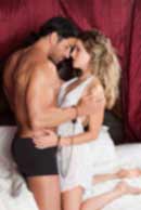 Sexy sensual heterosexual couple, man, young caucasian woman in love on bed kissing, hugging. Beautiful passionate couple is having sex in a bedroom. Portrait of passion, pleasure, sex, relationship. Copulating