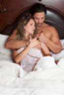 Sexy sensual heterosexual couple, man, young caucasian woman in love on bed kissing, hugging. Beautiful passionate couple is having sex in a bedroom. Portrait of passion, pleasure, sex, relationship. Copulating