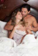 Sexy sensual heterosexual couple, man, young caucasian woman in love on bed kissing, hugging. Beautiful passionate couple is having sex in a bedroom. Portrait of passion, pleasure, sex, relationship. Copulating